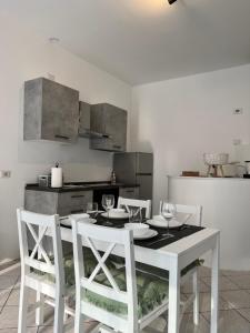 cocina con mesa blanca y sillas blancas en JACAM home free parking, en Albese Con Cassano