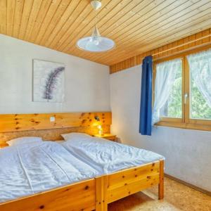 1 dormitorio con 1 cama con cabecero de madera y ventana en Hôtel Les Sources en Les Diablerets