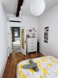 een slaapkamer met een bed en een dressoir bij La Belle de l’Isle in LʼIsle-sur-la-Sorgue