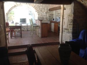 eine Küche und ein Wohnzimmer mit einem Tisch und Stühlen in der Unterkunft Ardèche les cigales gîte églantier avec piscine partagée in Grospierres