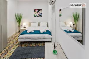1 dormitorio con 2 camas y espejo en Charming 2 bedroom townhouse, internal yard JDES1-1, en Il-Gżira