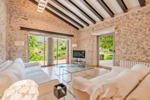 a living room with two white couches and a tv at Es Port Estellencs in Estellencs