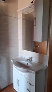 y baño con lavabo blanco y espejo. en Affittacamere Adri en Uzzano