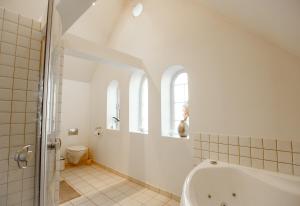 baño blanco con bañera y aseo en Lindebjerggårds Bed and Breakfast en Melby
