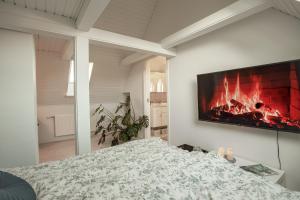 um quarto com uma cama e uma lareira na parede em Lindebjerggårds Bed and Breakfast em Melby