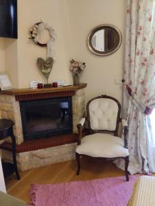 a living room with a chair and a fireplace at Valentini Guesthouse in Karpenisi