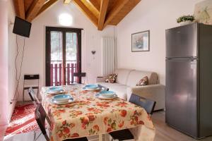 Appartamento Gaia في كاسبوجيو: غرفة معيشة مع طاولة وثلاجة