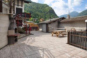 a patio with a wooden bench and a picnic table at Appartamento Gaia in Caspoggio