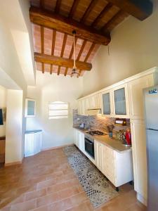 eine große Küche mit weißen Schränken und einem Kühlschrank in der Unterkunft Il Casaletto in Gavignano