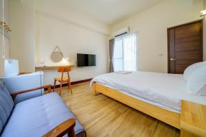 a bedroom with a large bed and a tv at Ryokou in Hualien City