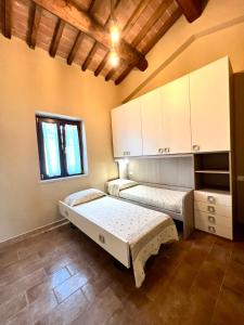 2 Betten in einem Zimmer mit Fenster in der Unterkunft Il Casaletto in Gavignano