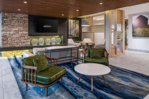 eine Lobby mit Stühlen, Tischen und einem TV in der Unterkunft Fairfield Inn & Suites by Marriott Menifee in Menifee