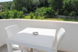 una mesa blanca y sillas en un balcón con vistas en Hotel Velipoja Village, en Velipojë