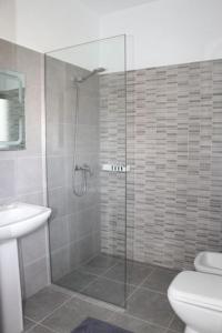 a bathroom with a shower with a toilet and a sink at Hotel Velipoja Village in Velipojë