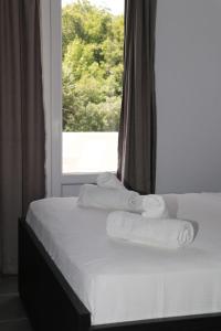 a bed with towels on it in front of a window at Hotel Velipoja Village in Velipojë