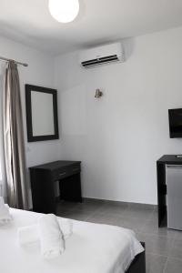 1 dormitorio con cama, espejo y escritorio en Hotel Velipoja Village en Velipojë