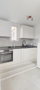 - une cuisine avec des placards blancs et un évier dans l'établissement Apartman Fani, à Dubrovnik