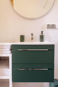 zieloną komodę w łazience z lustrem w obiekcie Apartamenty Koziołek w Srebrnej Górze