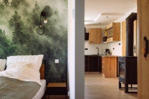 a bedroom with a wall mural of a forest at Apartamenty Koziołek in Srebrna Góra
