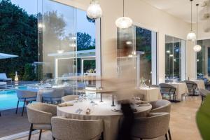 a restaurant with tables and chairs and a pool at Resort Miramonti in Forte dei Marmi