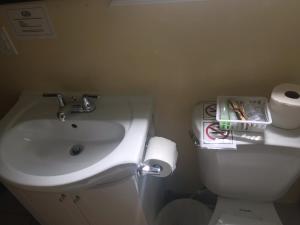 een badkamer met een wastafel en een toilet bij Hush Lodge and Cottages 
