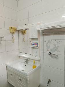 a white bathroom with a sink and a mirror at Sarada Hôtel in Ouagadougou