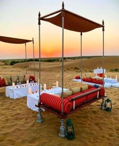 a bed in the sand in the desert at Raj Safari Resort in Sām