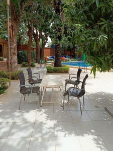 grupa krzeseł i stół na dziedzińcu w obiekcie Sarada Hôtel w mieście Wagadugu