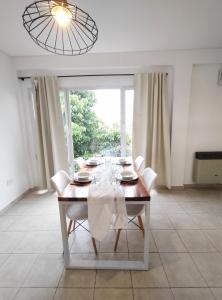 a dining room with a table with white chairs and a window at Estación Velez Cipolletti in Cipolletti +25 photos