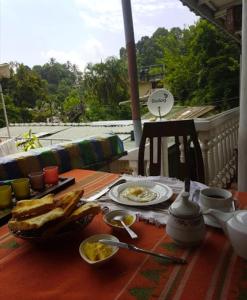 a table with a breakfast of eggs and toast at Sakura Hill in Kandy
