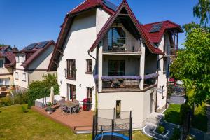 ein großes weißes Haus mit Balkon und Hof in der Unterkunft All World in Gdynia in Gdynia