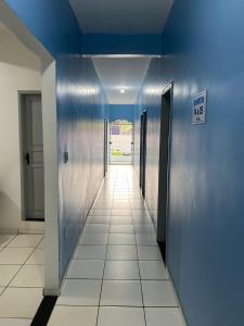 a hallway with blue walls and a tile floor at Pousada o Paraiso in Camamu