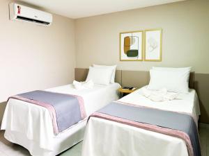 Cette chambre comprend 2 lits avec des draps blancs. dans l'établissement Hotel Haki, à Patos