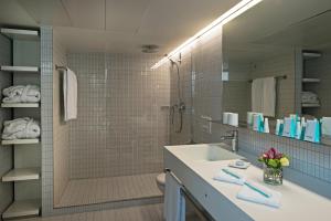 a bathroom with a sink and a shower and a mirror at Hotel Astoria in Lucerne