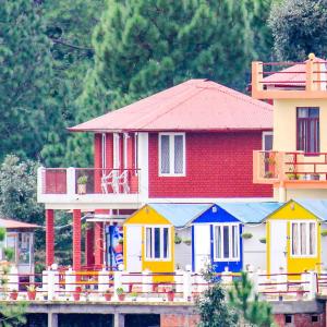 uma pequena casa com casas coloridas no topo de uma ponte em Himvadi Resorts Kausani em Kausani
