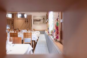 a view of a restaurant with tables and chairs at Hotel Glemmtalerhof in Saalbach-Hinterglemm