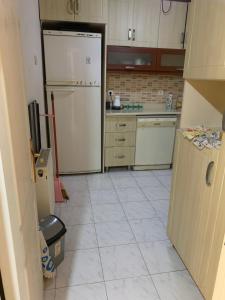 a kitchen with white appliances and a white tile floor at Apartment 3 bedrooms in Yalova