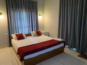 łóżko w pokoju z dużym oknem w obiekcie HOLLYWOOD Rooms w mieście Sultan Bathery