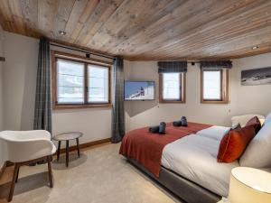 a bedroom with a bed and a table and chairs at Chalet Courchevel 1550, 7 pièces, 14 personnes - FR-1-562-47 in Courchevel