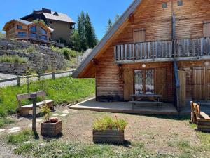 a wooden cabin with a picnic table in front of it at Chalet rénové 6 pers, TV connectée, WiFi, parking, animaux admis - FR-1-504-480 in Le Dévoluy