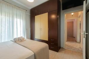 een slaapkamer met een bed met twee handdoeken erop bij Tommy's Family Apartment in Kateríni