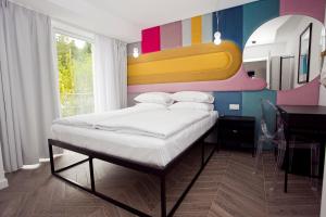 a bedroom with a bed with a colorful wall at Willowa NO. 5 APARTAMENTS in Wisła