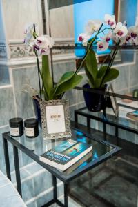 uma mesa de vidro com um livro e flores sobre ele em Projekt 44 Apartament em Oświecim