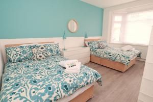 a bedroom with two beds and a mirror on the wall at Seafront House with balcony in Eastbourne
