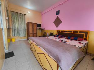 um quarto com uma cama grande e uma parede rosa em Himvadi Resorts Kausani em Kausani