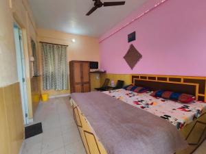 um quarto com uma cama grande e uma parede rosa em Himvadi Resorts Kausani em Kausani