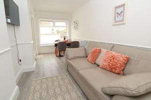 a living room with a couch and a table at Seafront House with balcony in Eastbourne