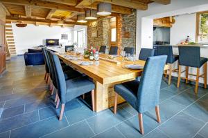 a dining room with a wooden table and blue chairs at Chalet Ladroit - OVO Network in Les Clefs