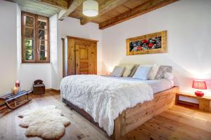 a bedroom with a large bed and a wooden ceiling at Chalet Ladroit - OVO Network in Les Clefs