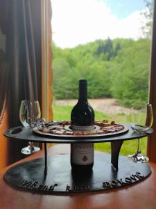 a tray with a bottle of wine and glasses on a window at Vikend kuća Đoković - Jahorina in Pale